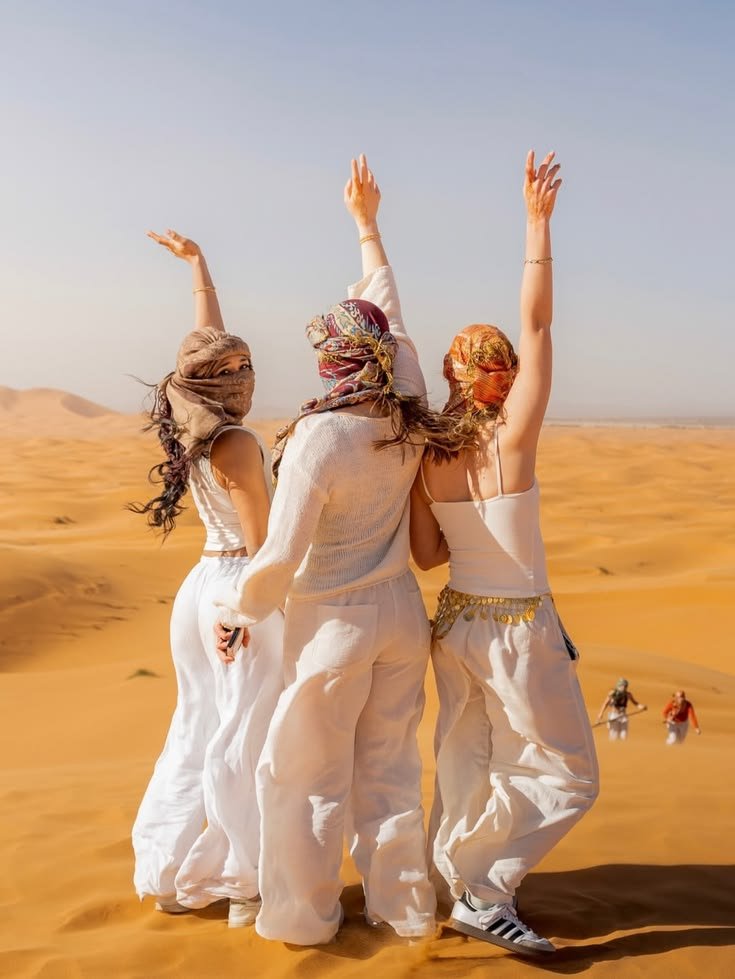 Guest sandboarding down a dune on a sunrise desert safari in Abu Dhabi